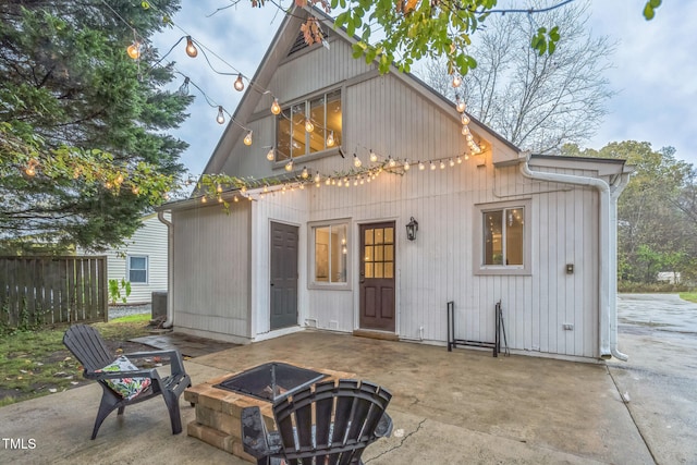 rear view of property featuring central AC, a patio, and an outdoor fire pit