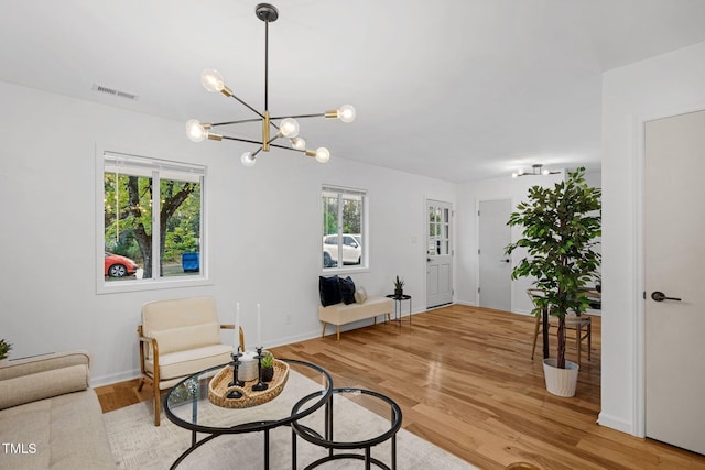 living room with hardwood / wood-style flooring and a notable chandelier