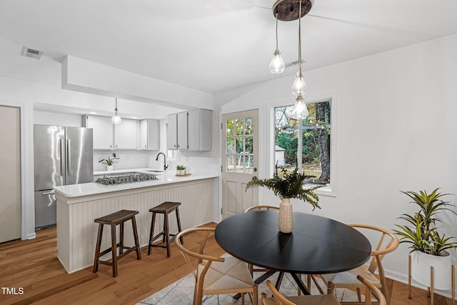 dining area featuring light wood-type flooring and sink