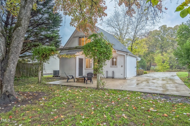 rear view of property featuring a lawn and a patio