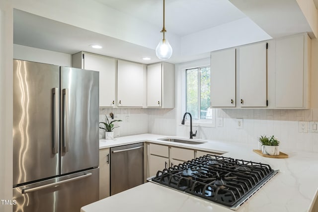 kitchen featuring backsplash, decorative light fixtures, sink, and appliances with stainless steel finishes