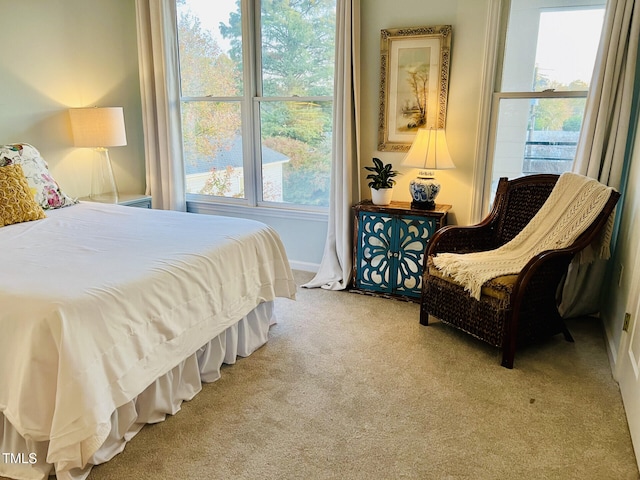 bedroom with light colored carpet and multiple windows