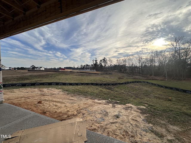 yard at dusk featuring a rural view