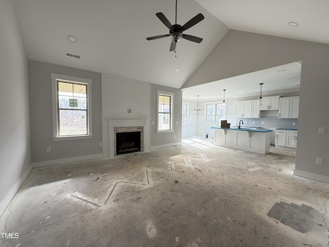 unfurnished living room with a fireplace, visible vents, a ceiling fan, high vaulted ceiling, and baseboards