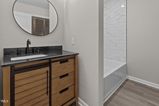 bathroom with hardwood / wood-style floors, vanity, and tiled shower / bath combo