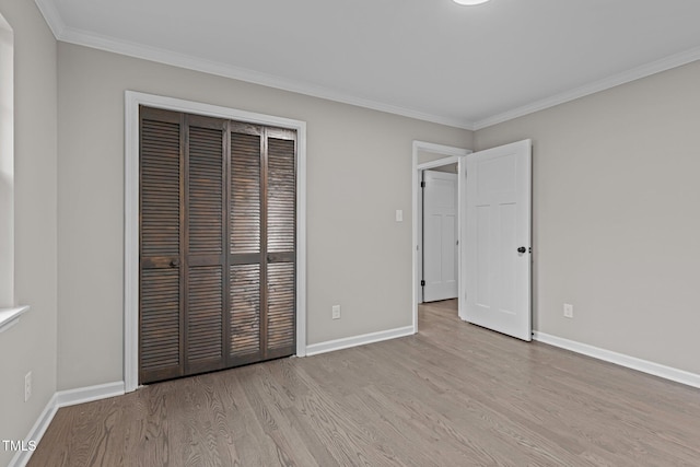 unfurnished bedroom featuring crown molding, a closet, and light hardwood / wood-style flooring