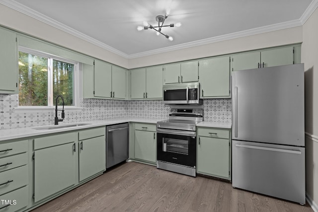 kitchen with crown molding, sink, stainless steel appliances, and green cabinetry