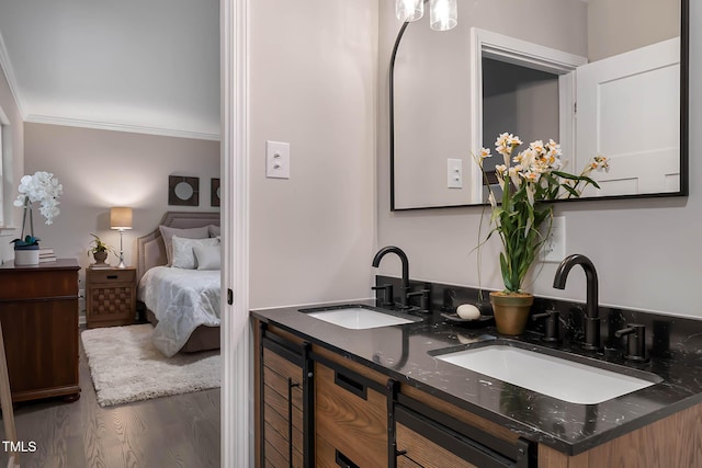 2704 Ross Rd, Durham, NC 27703 - ensuite bathroom featuring wood finished floors, crown molding, and double vanity
