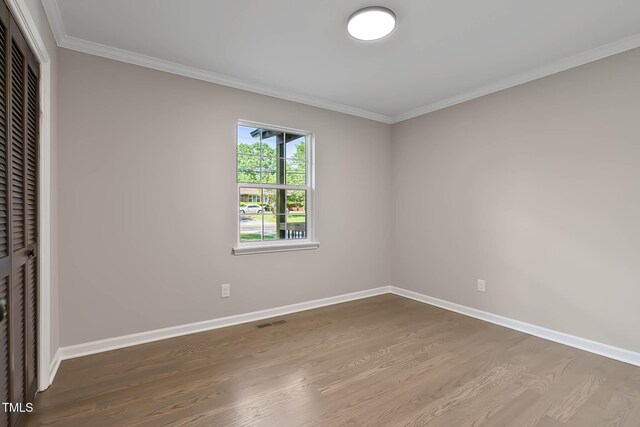 2704 Ross Rd, Durham, NC 27703 - unfurnished bedroom featuring wood finished floors, crown molding, a closet, and baseboards