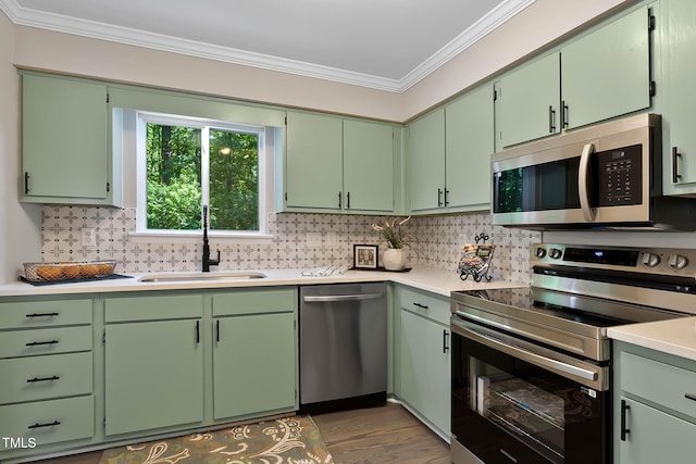 2704 Ross Rd, Durham, NC 27703 - kitchen featuring stainless steel appliances, a sink, crown molding, decorative backsplash, and light countertops