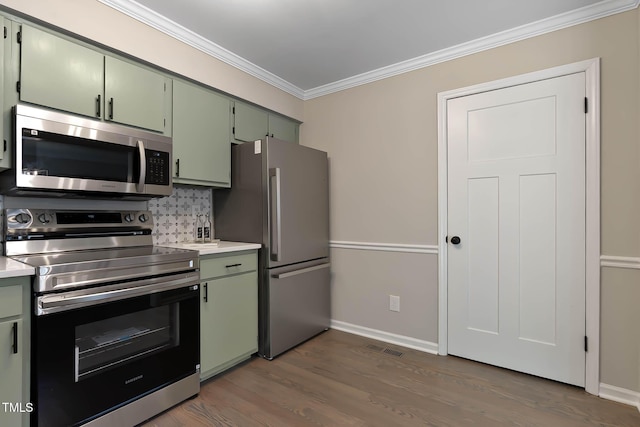 2704 Ross Rd, Durham, NC 27703 - kitchen with stainless steel appliances, green cabinets, crown molding, light countertops, and dark wood-style floors