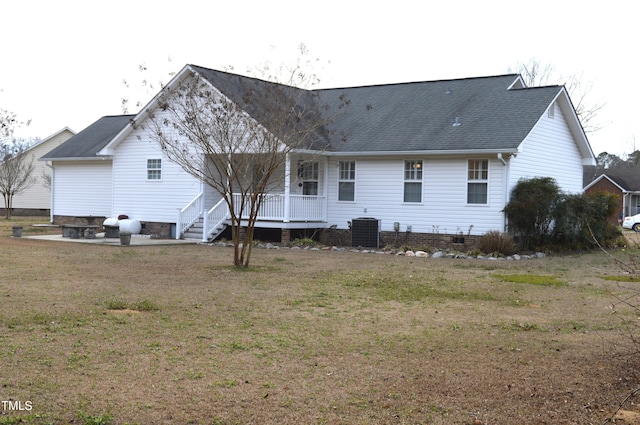 back of property featuring a lawn and central air condition unit