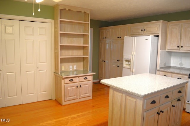 kitchen with decorative backsplash, light brown cabinetry, white appliances, light hardwood / wood-style floors, and a kitchen island