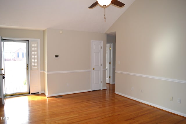 empty room with ceiling fan, wood-type flooring, and vaulted ceiling