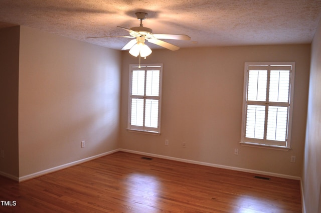 unfurnished room with wood-type flooring, a textured ceiling, and ceiling fan