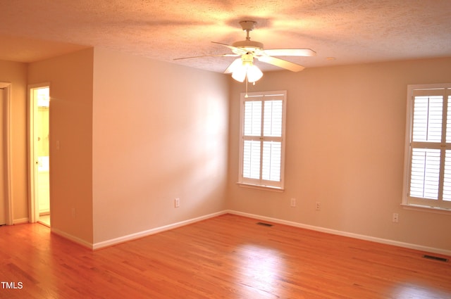 spare room with hardwood / wood-style flooring, a wealth of natural light, and ceiling fan