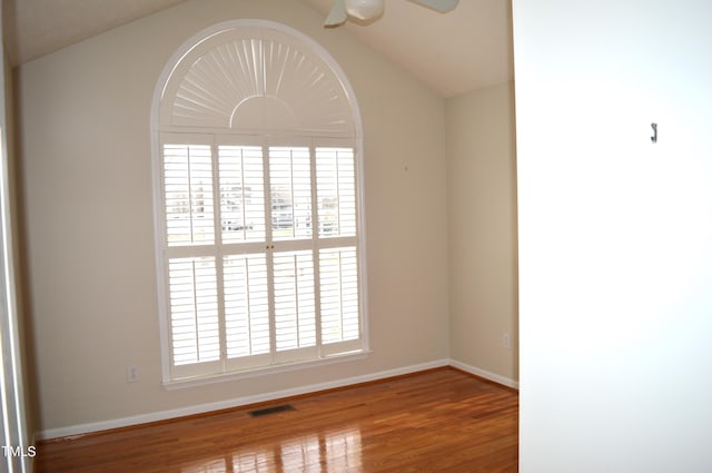 empty room featuring wood-type flooring, vaulted ceiling, and ceiling fan