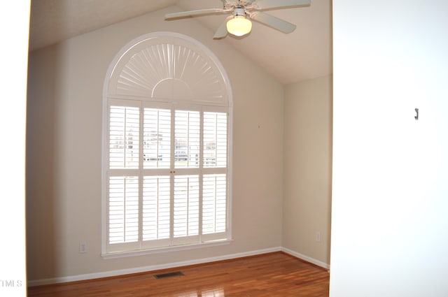 spare room with ceiling fan, wood-type flooring, and vaulted ceiling