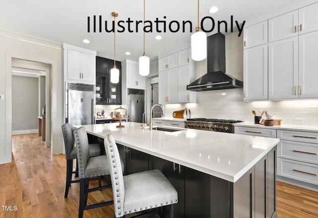 kitchen with white cabinets, a spacious island, wall chimney range hood, and sink