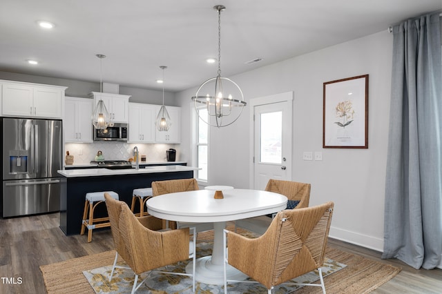 dining area featuring a notable chandelier, dark hardwood / wood-style flooring, and sink