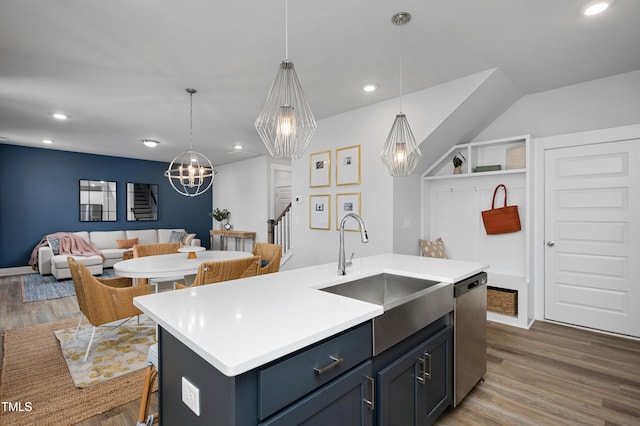 kitchen featuring pendant lighting, a kitchen island with sink, sink, hardwood / wood-style flooring, and stainless steel dishwasher