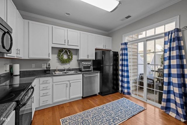 kitchen with black appliances, white cabinets, sink, ornamental molding, and light hardwood / wood-style floors