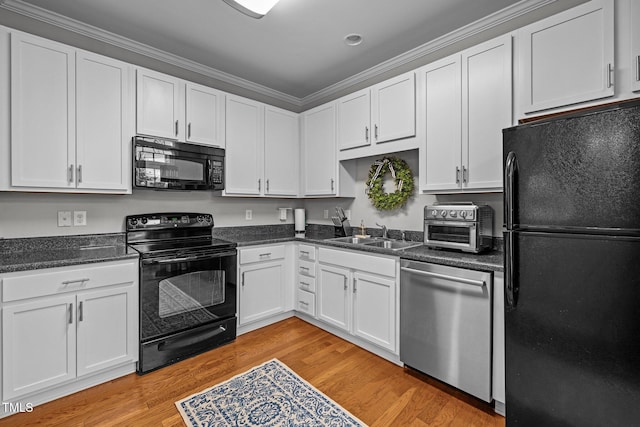 kitchen with white cabinetry, sink, light hardwood / wood-style flooring, black appliances, and ornamental molding