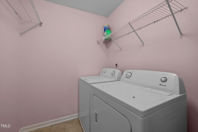 laundry room featuring washer and clothes dryer and light tile patterned floors