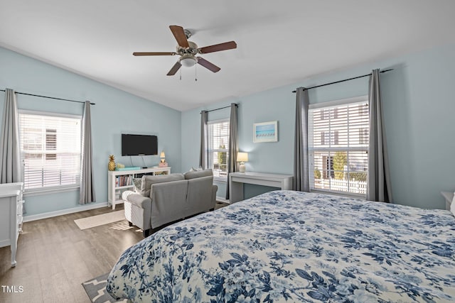 bedroom with hardwood / wood-style floors, multiple windows, lofted ceiling, and ceiling fan