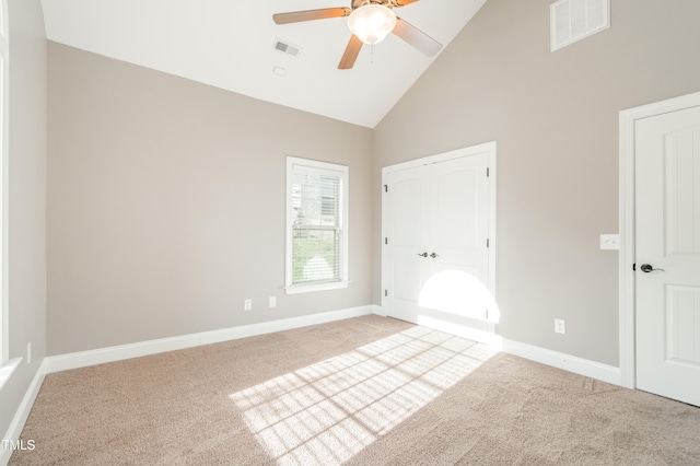 unfurnished bedroom featuring carpet, high vaulted ceiling, and ceiling fan