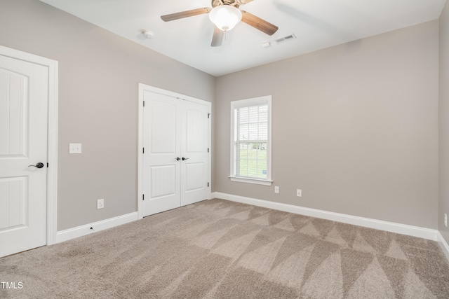 unfurnished bedroom featuring light carpet and ceiling fan