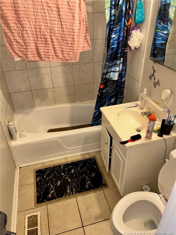 full bathroom with tile patterned floors, shower / bath combo with shower curtain, vanity, and toilet