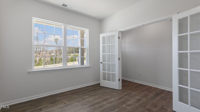 spare room featuring french doors and dark hardwood / wood-style floors