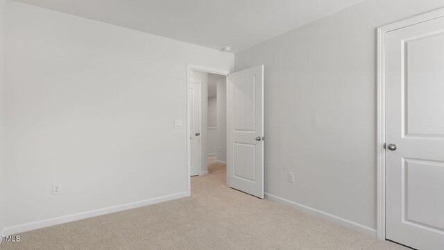 unfurnished bedroom featuring light carpet