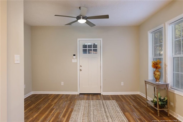 foyer entrance with ceiling fan, dark hardwood / wood-style flooring, and a textured ceiling