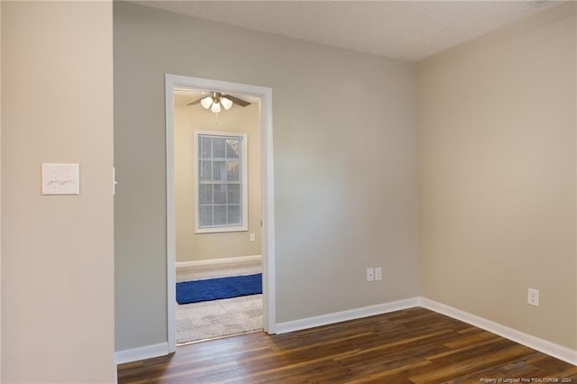 spare room with a textured ceiling, ceiling fan, and dark hardwood / wood-style floors