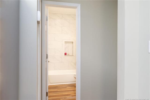 bathroom with hardwood / wood-style flooring and a tub