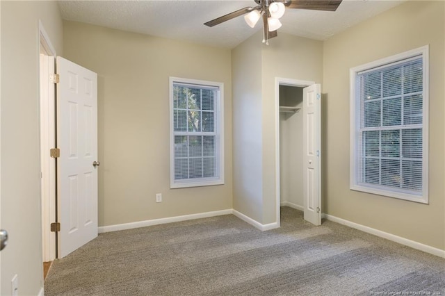 unfurnished bedroom with carpet, a textured ceiling, a closet, and ceiling fan