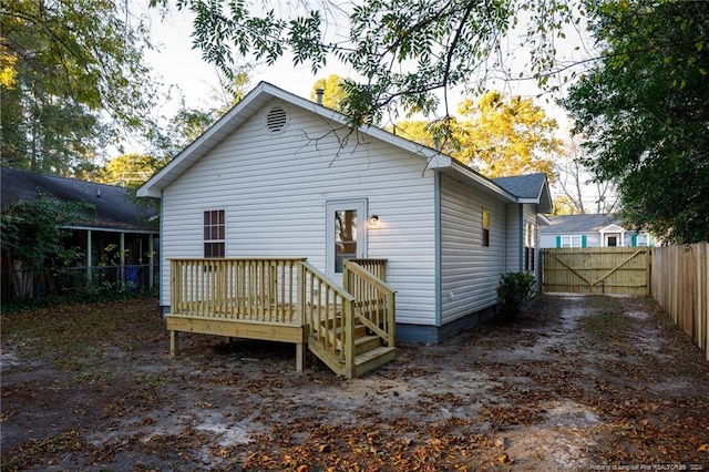 rear view of property featuring a wooden deck