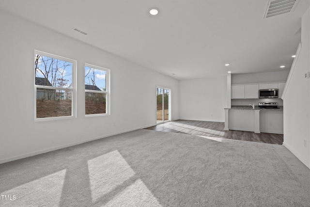 unfurnished living room with light colored carpet