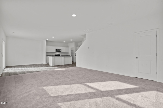 unfurnished living room with light colored carpet