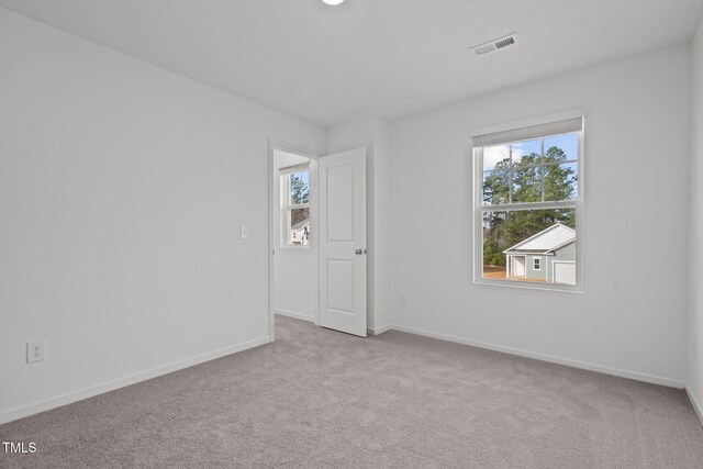 spare room featuring light carpet