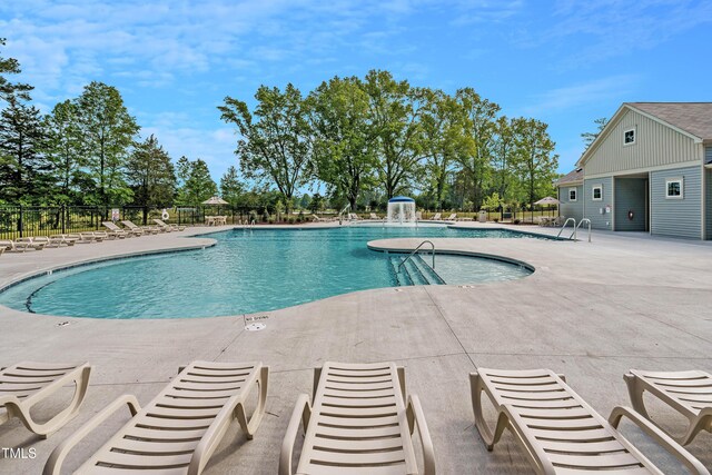 view of swimming pool with pool water feature and a patio area