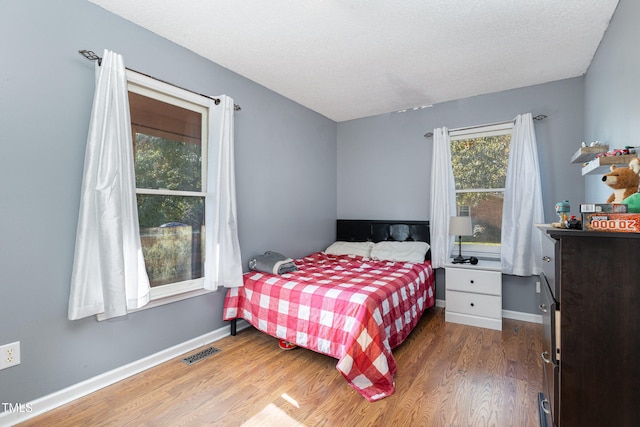 bedroom with wood-type flooring and a textured ceiling