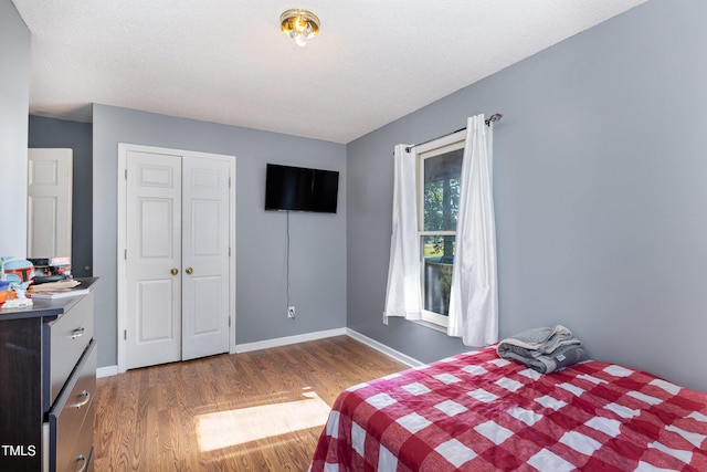 bedroom featuring a textured ceiling, dark wood-type flooring, and a closet