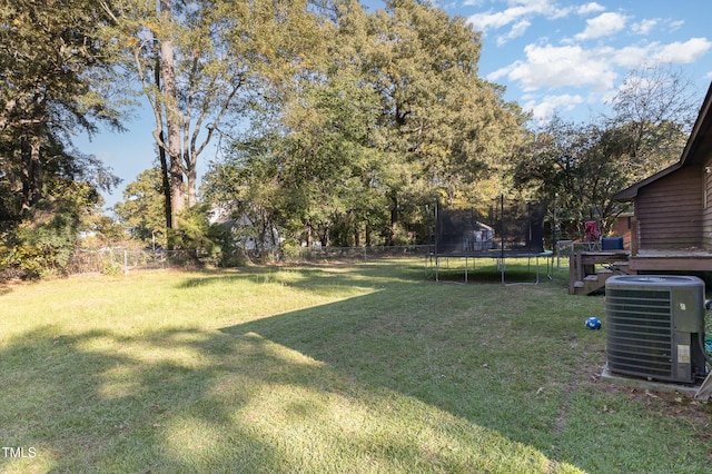 view of yard featuring central air condition unit and a trampoline