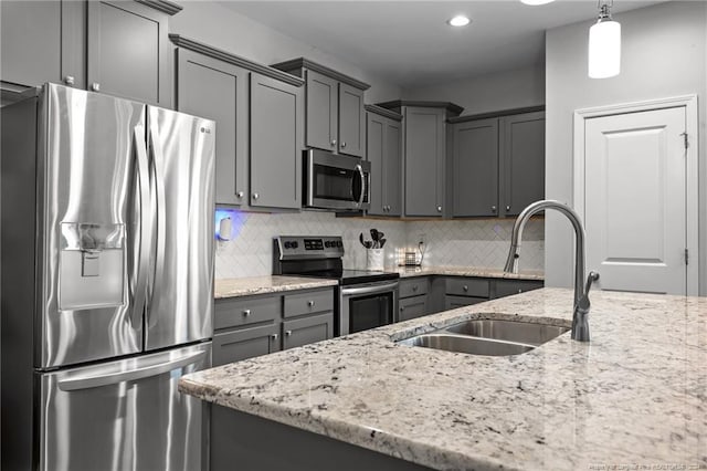 kitchen featuring decorative backsplash, stainless steel appliances, sink, pendant lighting, and gray cabinets