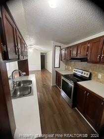 kitchen featuring dark hardwood / wood-style flooring, stainless steel range with electric stovetop, dark brown cabinets, a textured ceiling, and sink