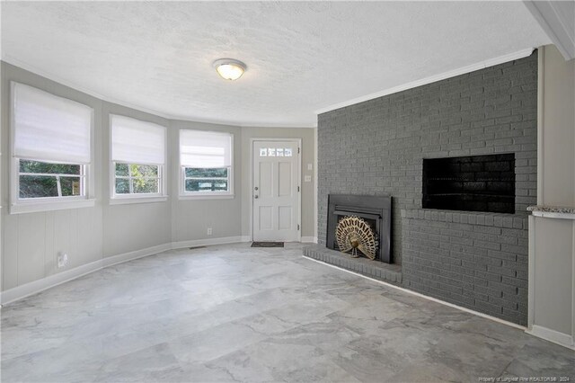 unfurnished living room featuring a textured ceiling, ornamental molding, and brick wall