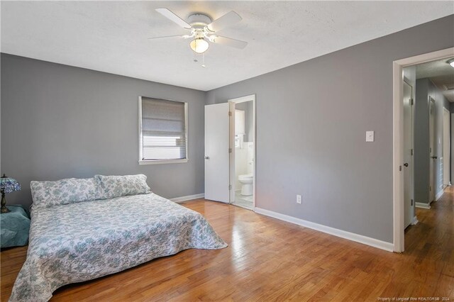 bedroom with connected bathroom, ceiling fan, and wood-type flooring